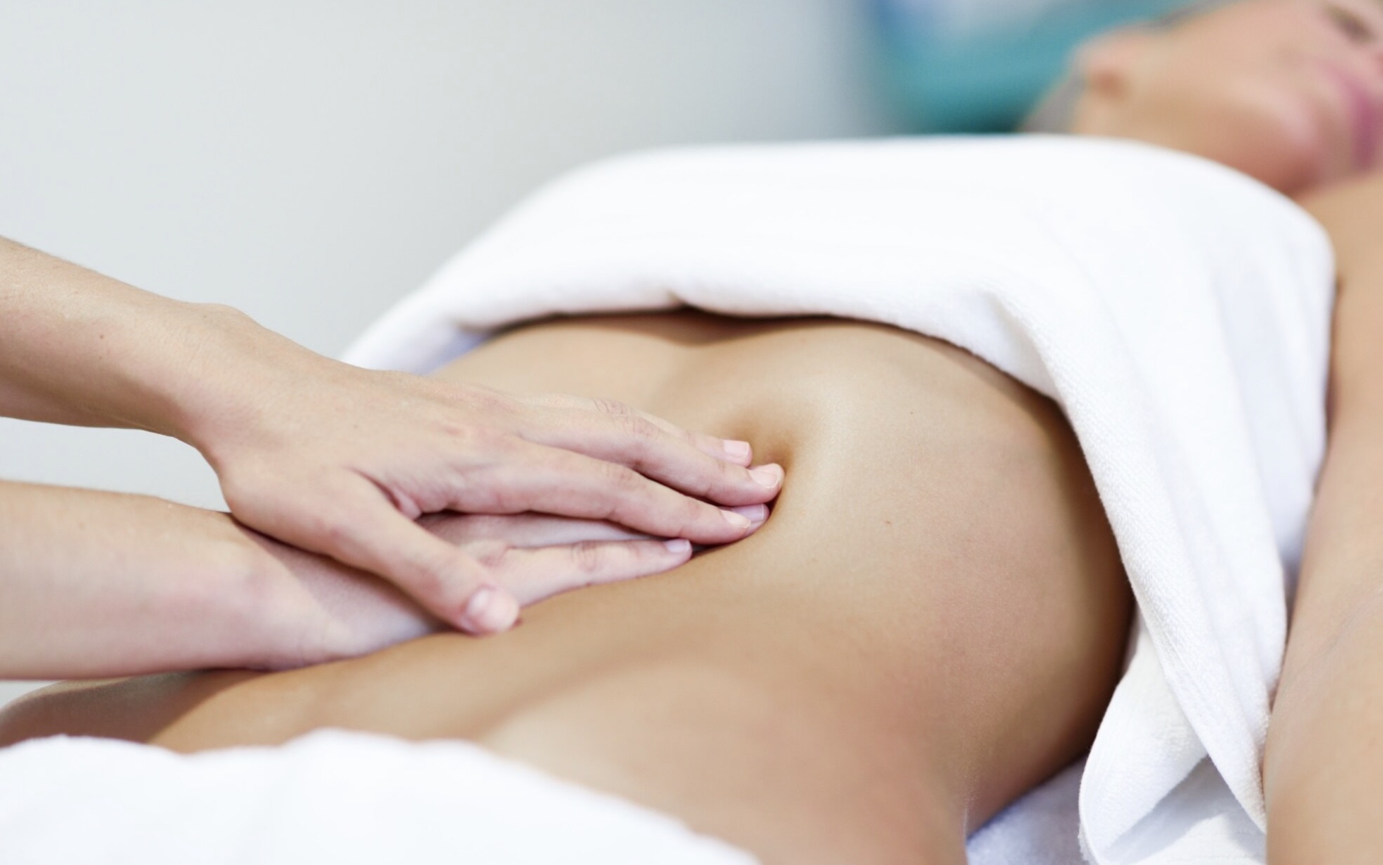 Mains de praticienne en contact doux sur l'abdomen lors d'une séance de Chi Nei Tsang